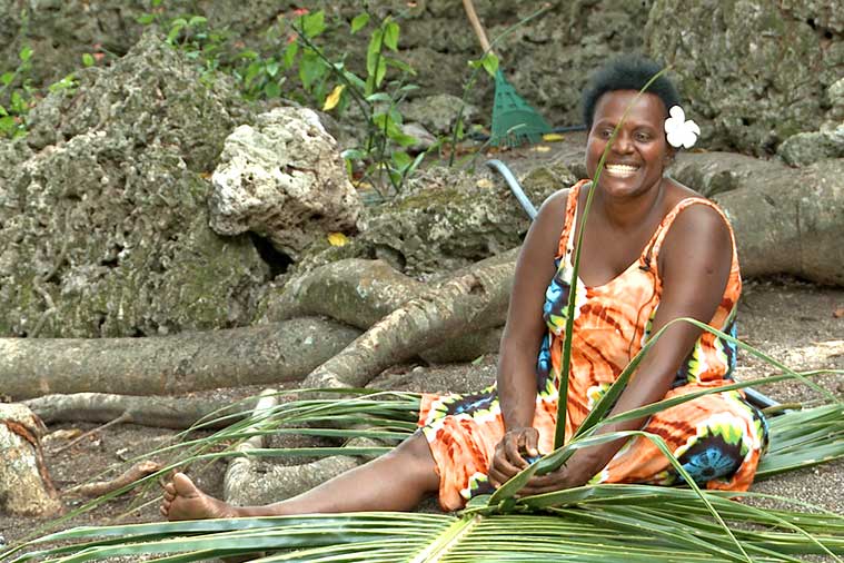 A woman weaving a palm leaf